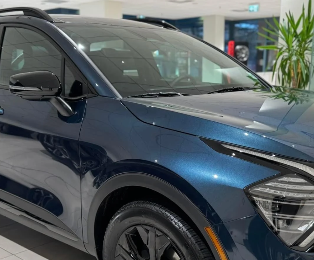 Blue Kia SUV parked inside dealership showroom