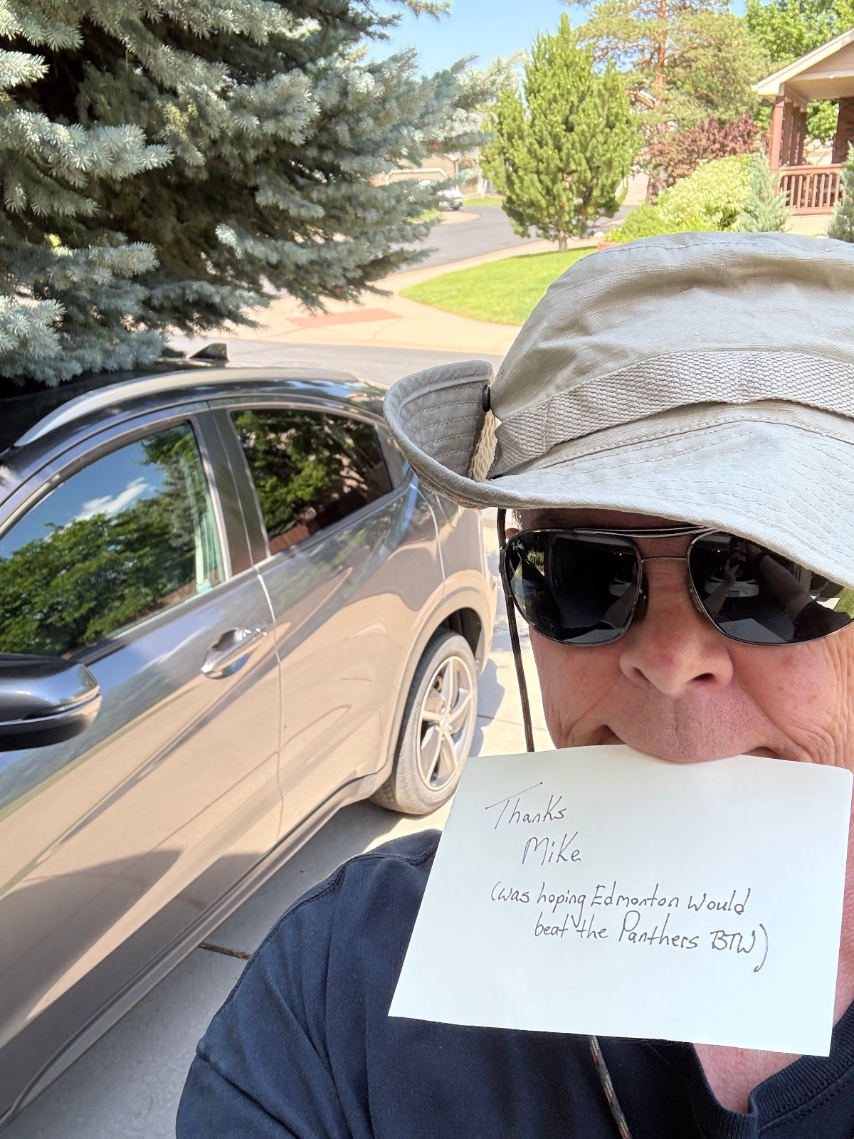 Happy customer holding a thank-you note for Mike after buying a car with GetMyCarDeal.com