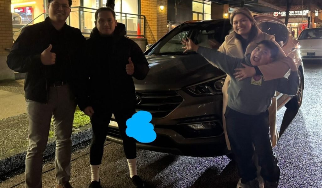 Ken from GettingDeal.com poses at night with a happy family in front of their newly purchased SUV, celebrating another smooth car buying experience.